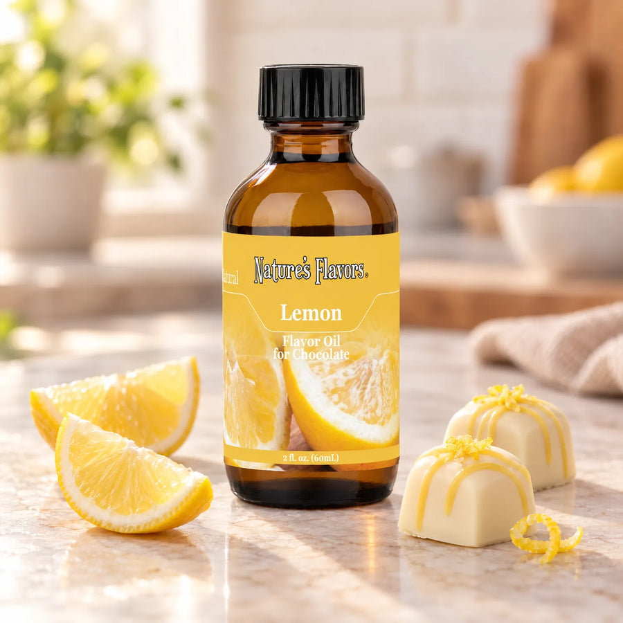 Nature's Flavors Lemon Flavor Oil for Chocolate bottle beside lemon wedges and white chocolate bonbons decorated with lemon zest.