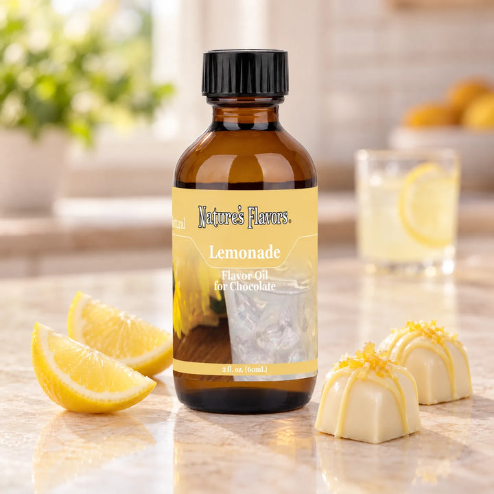 Nature's Flavors Lemonade Flavor Oil for Chocolate bottle beside lemon wedges and white chocolate bonbons, with lemonade in the background.