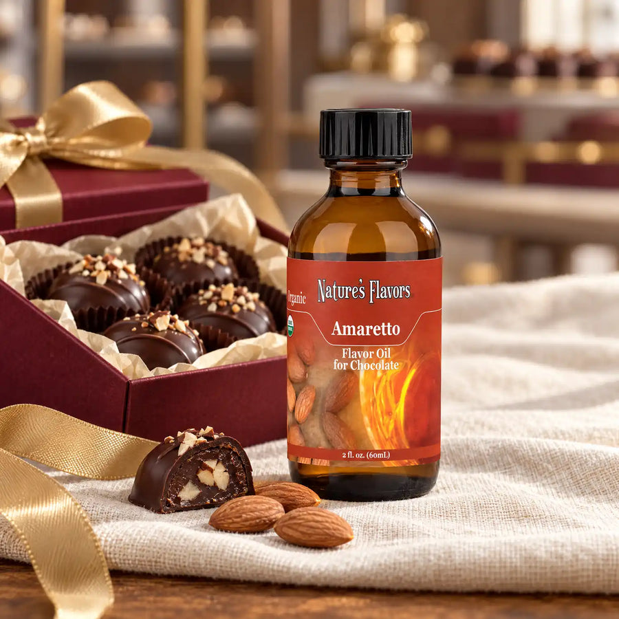 Nature's Flavors Organic Amaretto Flavor Oil for Chocolate bottle beside almonds and a burgundy gift box of chocolate truffles.