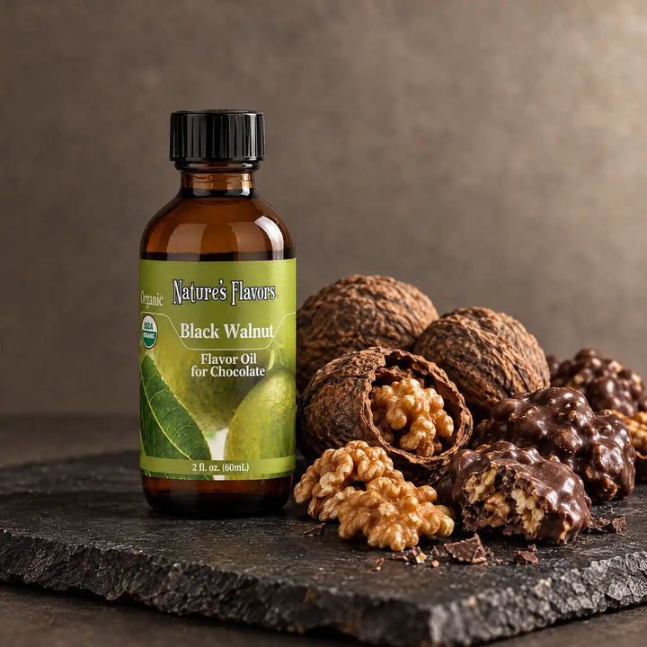 Nature's Flavors Organic Black Walnut Flavor Oil For Chocolate, 2-ounce bottle, with walnuts and chocolate nut clusters on slate.