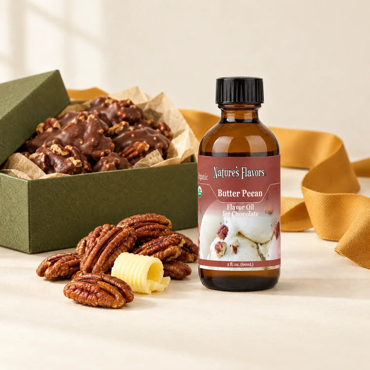 Nature's Flavors Organic Butter Pecan Flavor Oil For Chocolate, 2-ounce bottle, with pecans, butter and boxed chocolate clusters on a gift table.