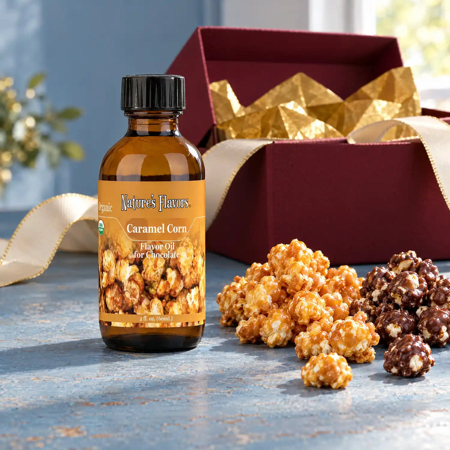 Nature's Flavors Organic Caramel Corn Flavor Oil for Chocolate, 2-ounce bottle, with caramel popcorn and chocolate-coated popcorn on a gift table.