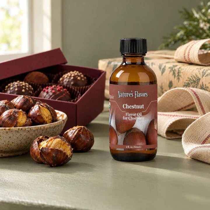 Nature's Flavors Organic Chestnut Flavor Oil For Chocolate, 2-ounce bottle, with chestnuts and boxed chocolate truffles on a gift table.
