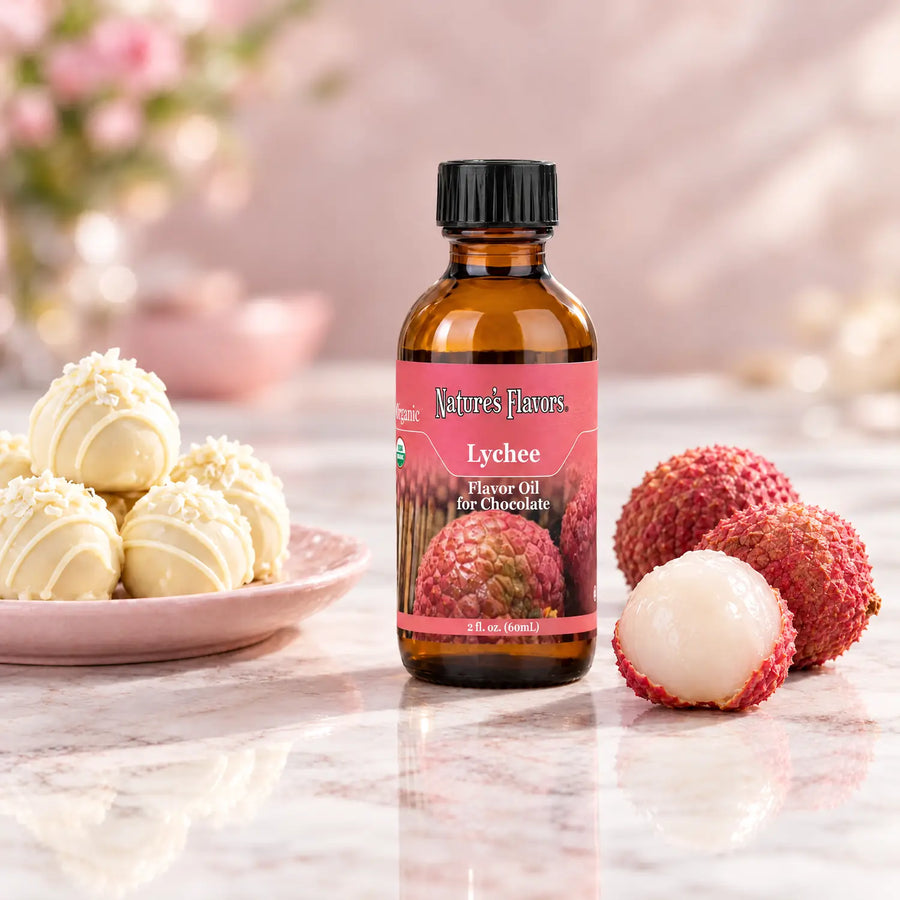Nature's Flavors Organic Lychee Flavor Oil For Chocolate, 2-ounce bottle, with lychees and white chocolate truffles on marble.
