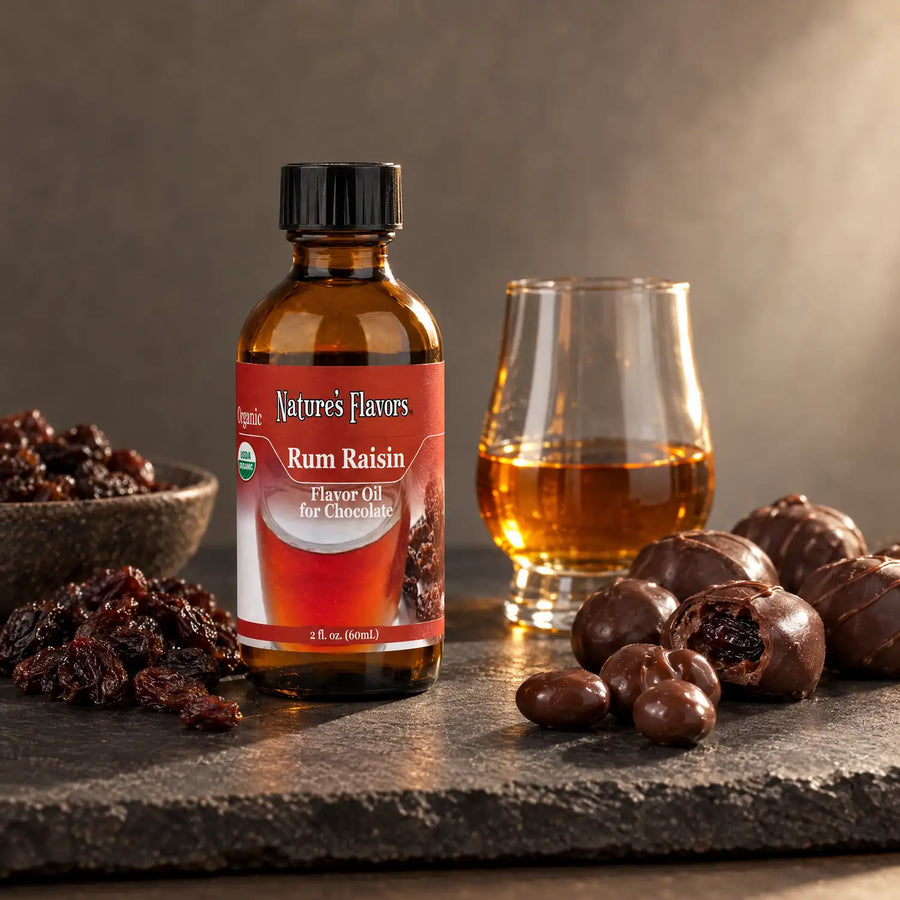 Nature's Flavors Organic Rum Raisin Flavor Oil For Chocolate, 2-ounce bottle, with raisins, rum and chocolate truffles on slate.