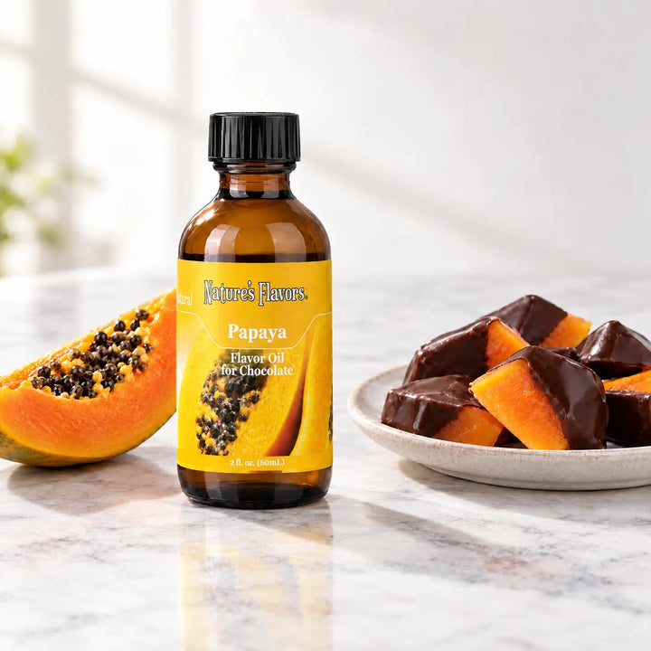 Nature's Flavors Papaya Flavor Oil for Chocolate, 2-ounce bottle, with papaya and chocolate-dipped fruit on marble.