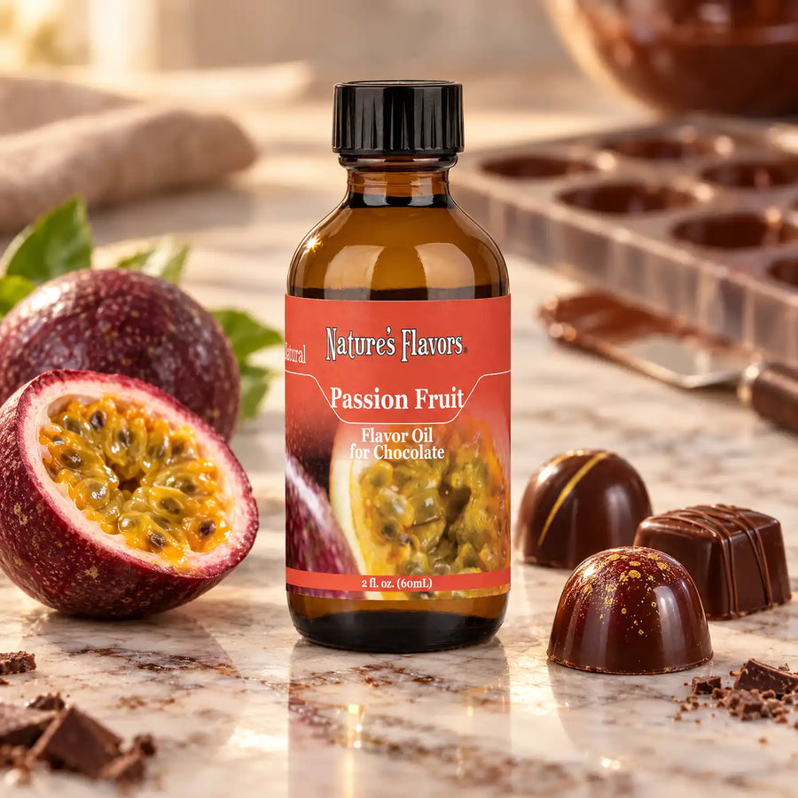 Nature's Flavors Passion Fruit Flavor Oil for Chocolate bottle beside halved passion fruit and chocolate bonbons on a chocolatier workbench.