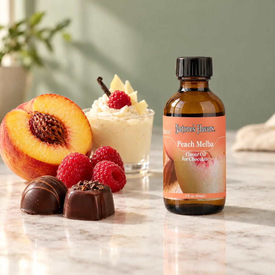 Nature's Flavors Peach Melba Flavor Oil for Chocolate, 2-ounce bottle, with peach, raspberries and chocolate bonbons on marble.