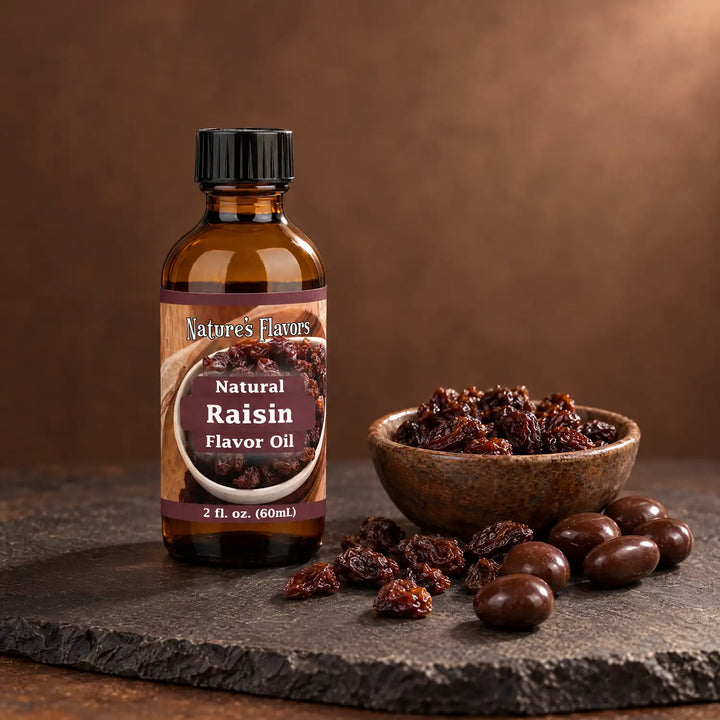 Nature's Flavors Raisin Flavor Oil, Natural, 2-ounce bottle, with raisins and chocolate-covered raisins on slate.
