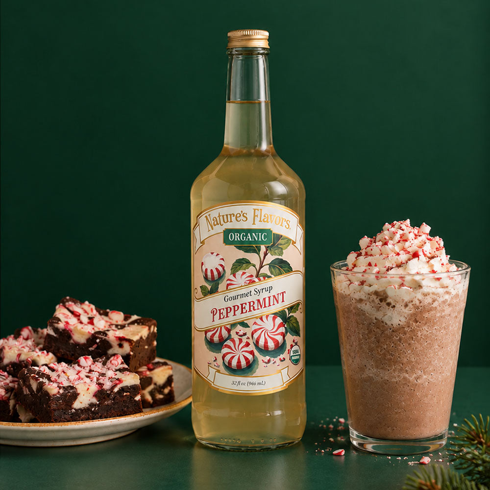 A bottle of Nature's Flavors Peppermint Syrup stands next to an iced blended peppermint mocha and peppermint brownies on a dark green background.